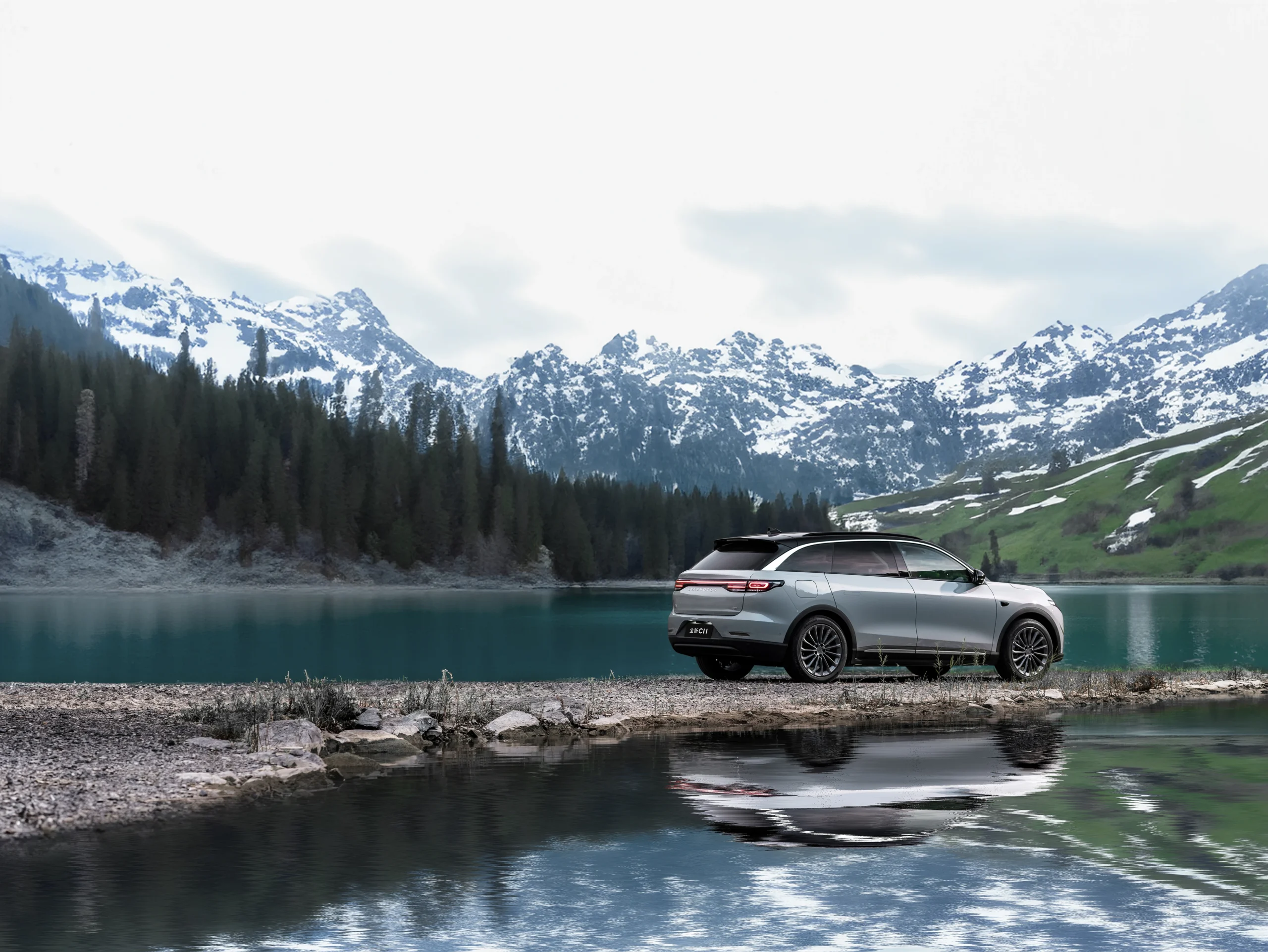 SUV Leapmotor C11 frente a un lago con montañas nevadas al fondo